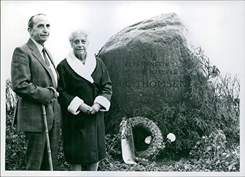 Vintage fotografija muškarca i žene koja pozira na spomen H. C. Thomsena koja podsjeća narod junaka svjetskog rata 2. Tekst na kamenu